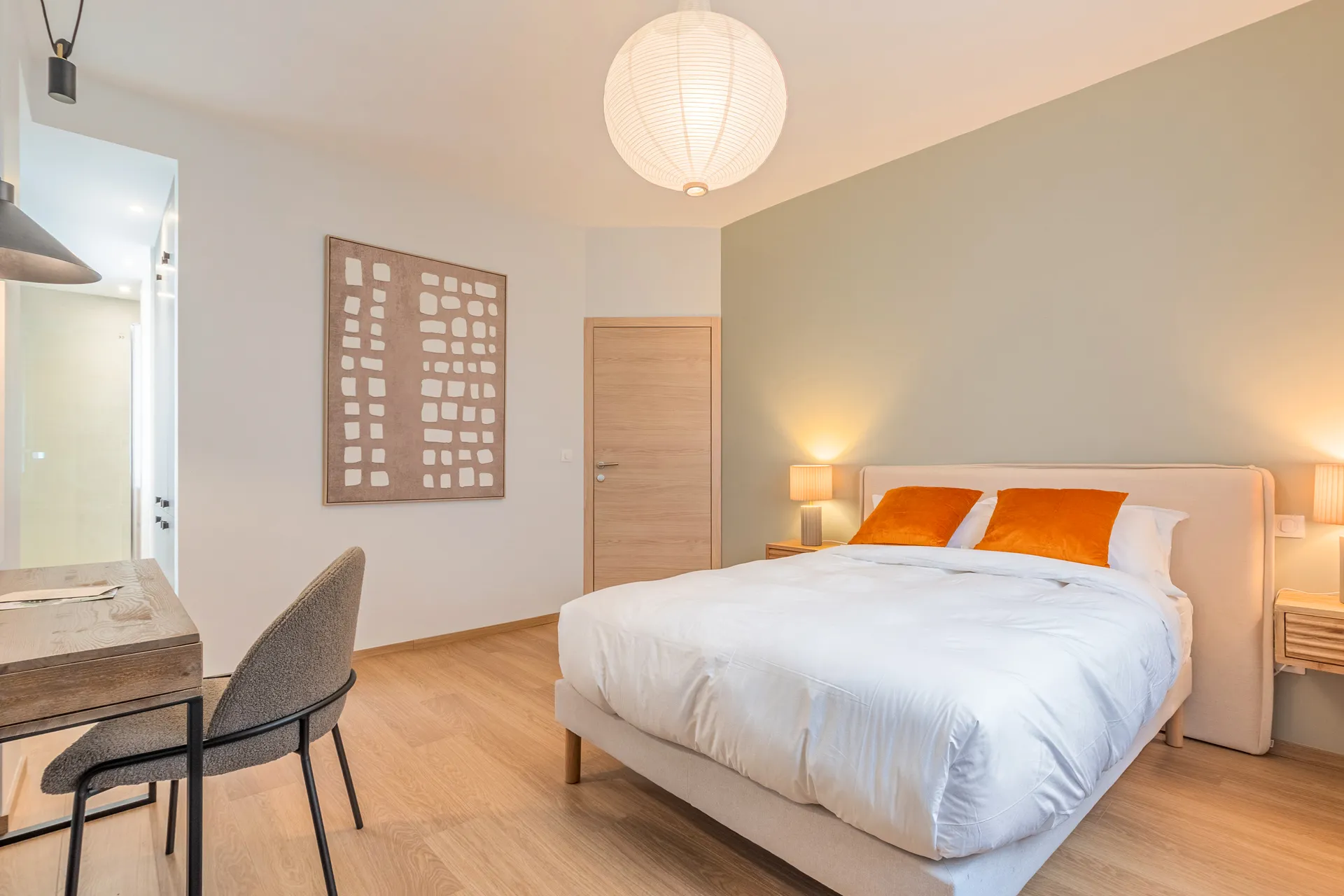 Chambre — lit double, bureau et parquet clair, lumière du jour